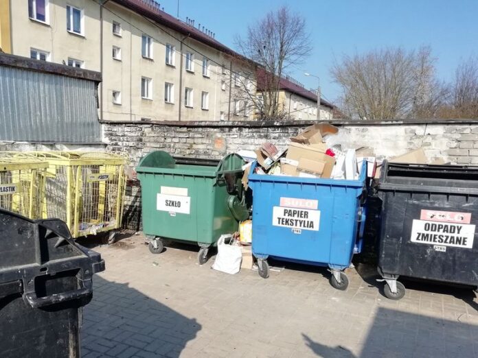 kolorowe pojemniki do segregacji na śmieci koło bloku