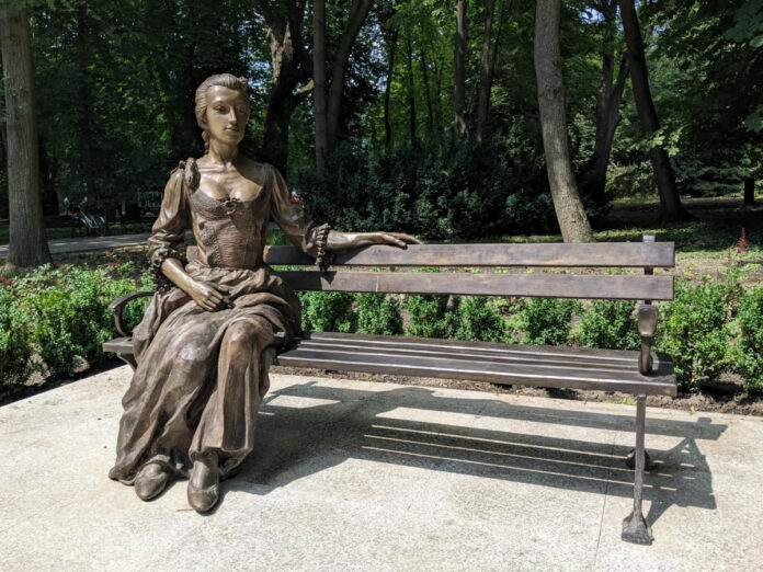 Pomnik kobiety siedzącej na ławce w parku