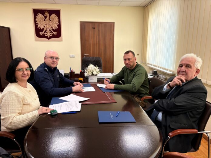 Trzech mężczyzn i kobieta siedzą przy stole w biurze, prowadząc rozmowę w profesjonalnej atmosferze.