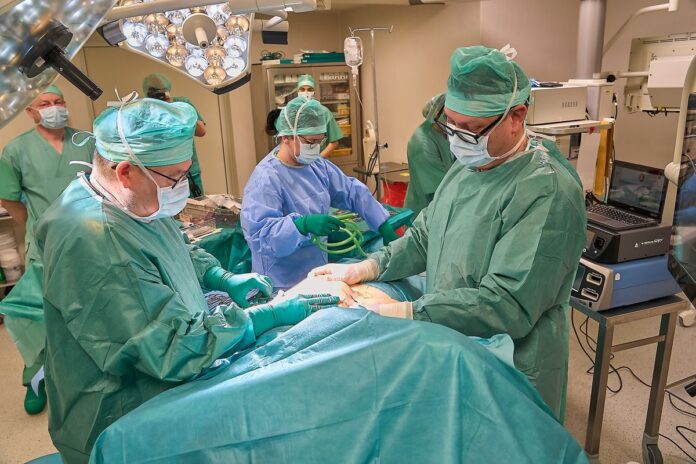 Grupa chirurgów przeprowadza operację w sali operacyjnej, skoncentrowana na precyzyjnych działaniach medycznych.