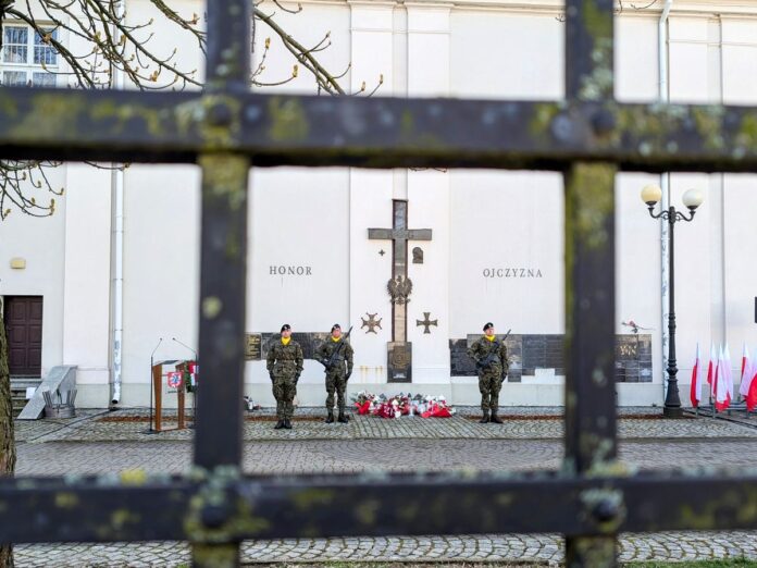 Widok na krzyż stojący przy ścianie budynku