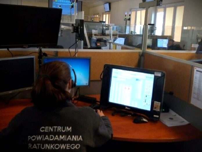 Kobieta pracuje przy biurku, siedząc przed włączonym komputerem.