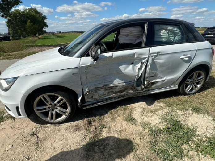 samochód po wypadku z uszkodzoną karoserią stoi na drodze