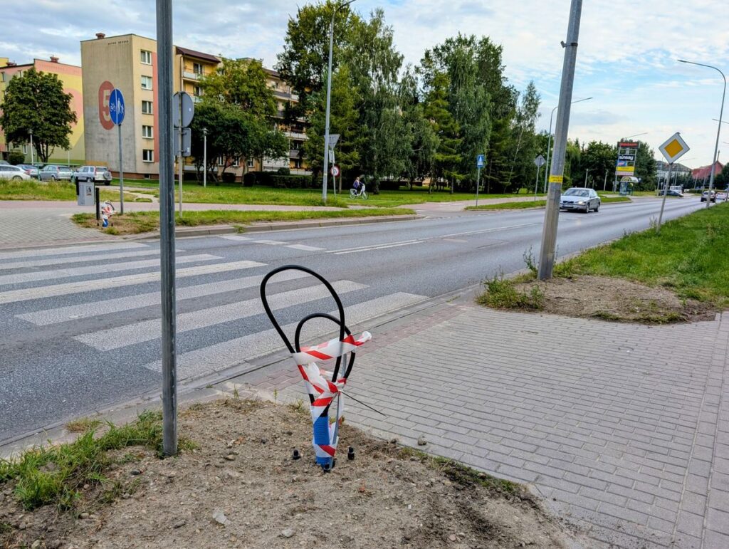 Przejście dla pieszych przy drodze w mieście w tle bloki i samochody.
