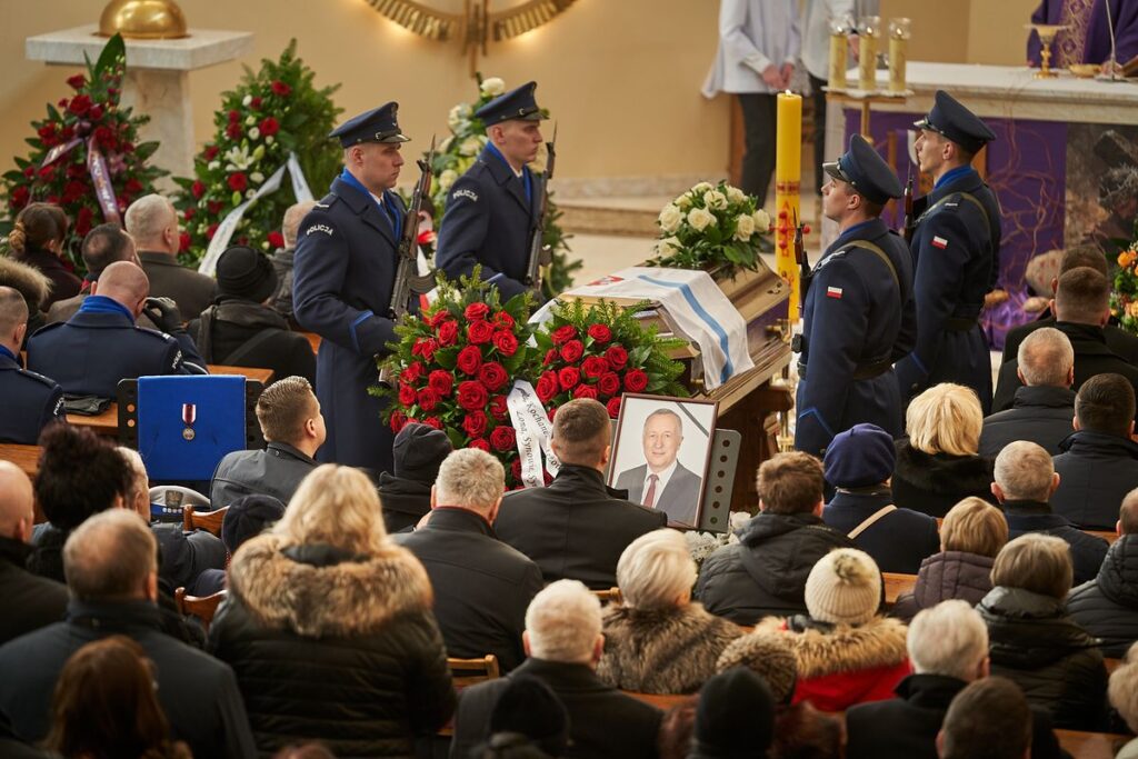 Uroczystości pogrzebowe, przy trumnie z zdjęciem zmarłego wartę pełni 4 policjantów.