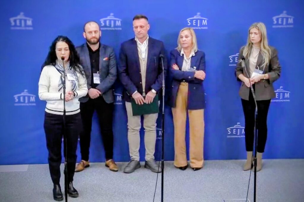 Pięć osób (3 kobiety, 2 mężczyzn) stoi na niebieskim tle z napisem "sejm"