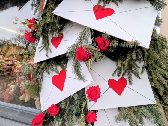 Dekoracja walentynkowa wykonana z kopert z naklejonymi czerwonymi sercami.