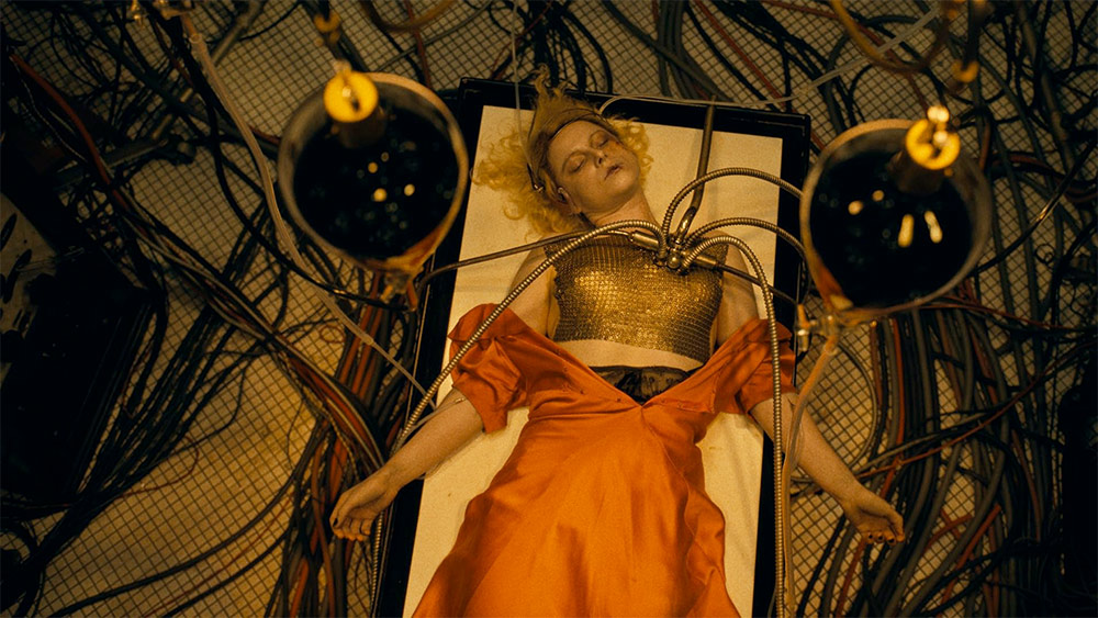 Kobieta w pomarańczowej sukience zawieszona w klatce.