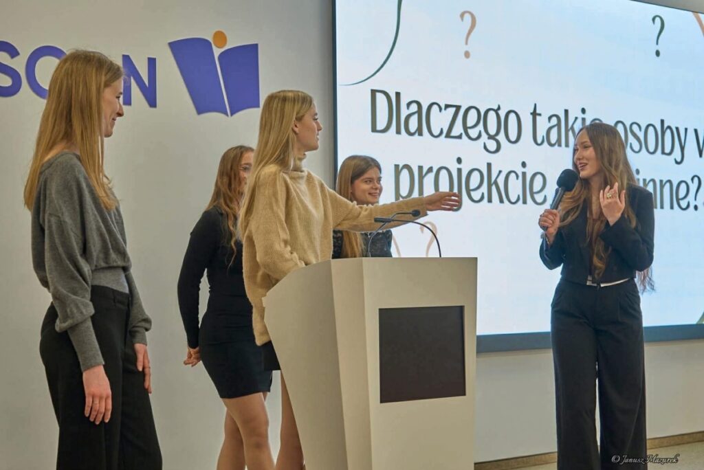 Kobiety stoją przy podium i prowadzą dyskusję.