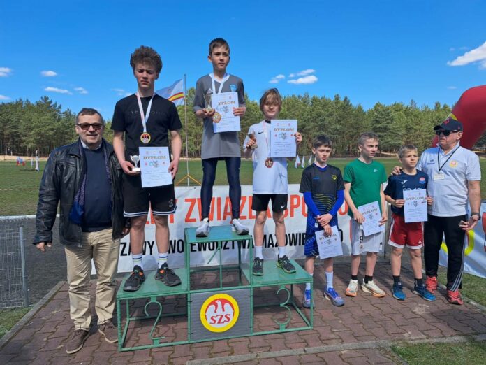 Grupa chłopców i dziewcząt na podium trzymająca swoje certyfikaty.