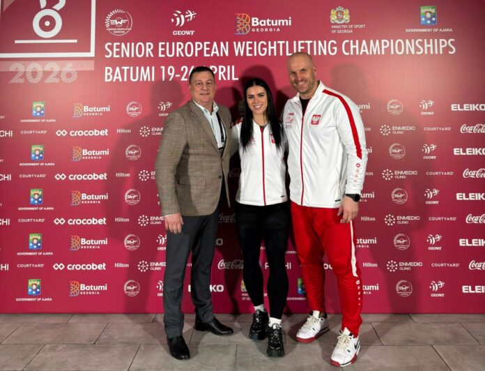 Mężczyzna i kobieta stoją razem przed intensywnie czerwoną ścianą.