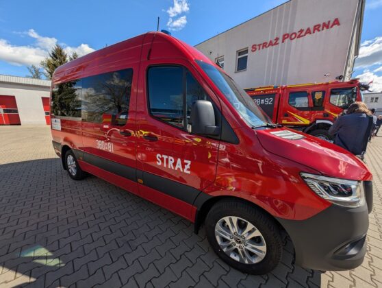 Czerwony w&oacute;z strażacki zaparkowany przed budynkiem