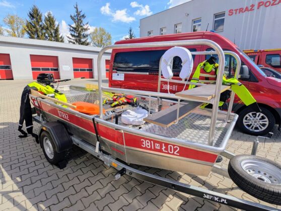 Ł&oacute;dź i w&oacute;z strażacki stoją obok siebie