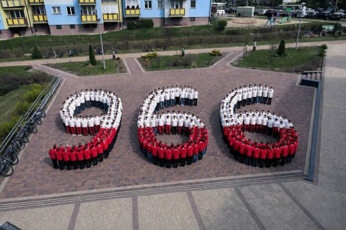 Liczba 966 będąca rokiem chrztu Polski ułożona z uczniów ubranych w białe i czerwone stroje.