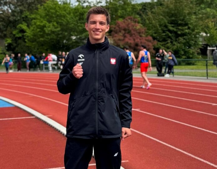 młody mężczyzna w stroju sportowym uśmiecha się do aparatu