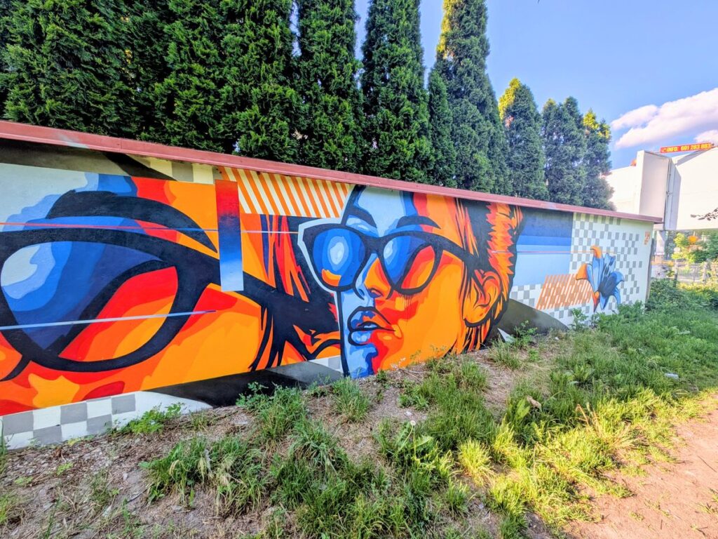 Kolorowy mural z geometrycznymi kształtami i kobiecą twarzą
