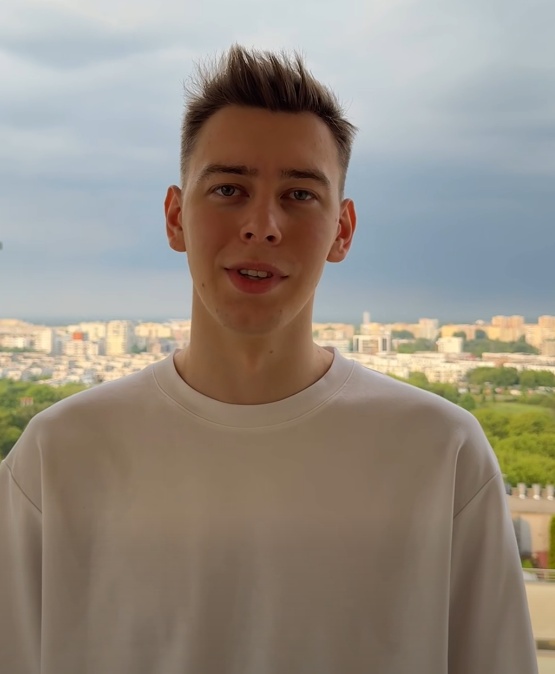 Młody mężczyzna w białej koszulce na tle panoramy miasta