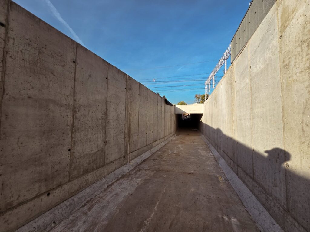 Betonowy tunel podziemny z wysokimi ścianami oporowymi pod trakcją kolejową